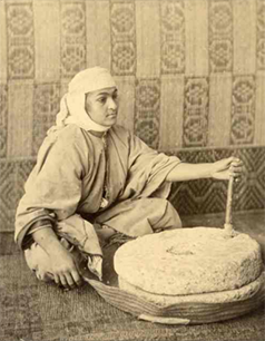 Femme posant avec un moulin en pierre, Tanger circa 1880